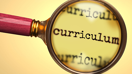 Magnifying glass hovering over the word curriculum, repeated three times