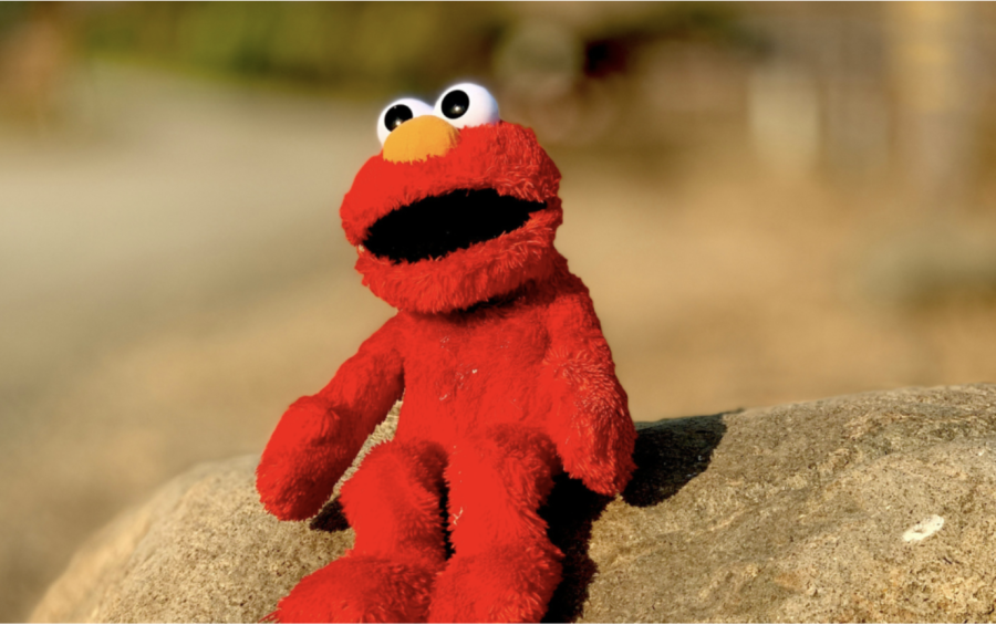 Elmo sitting on a rock