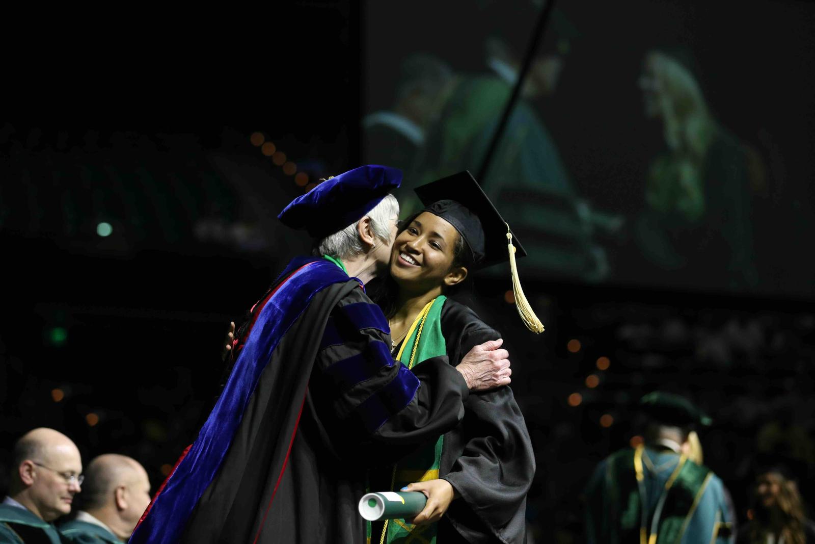 chelsea sanchez at graduation being hugged on stage by our late dean Dr. Diana Garland